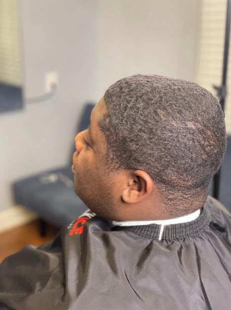 Man seated in a barber chair about to get a haircut